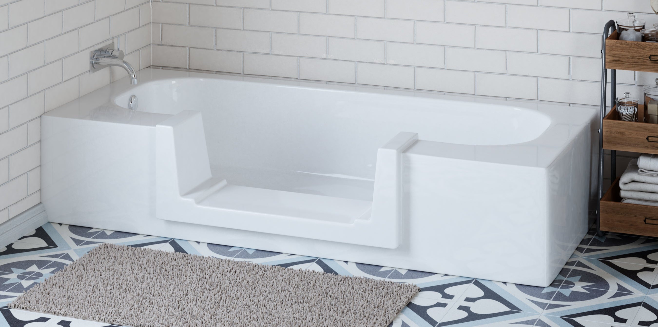 White bathtub in a bathroom with tiled walls and patterned floor.